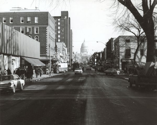 View down center of State Street towards Lake Street. On the left is the University Book Store, and on further down across Lake Street is Rennebohm's and Warner Medlin. On the corner on the right is Brown's Book Shop.