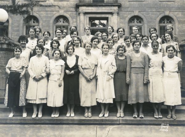 Group portrait of Barnard Hall U.W. female students posing in front of dormitories at 934 University Avenue.