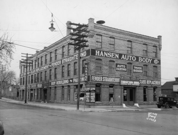 Torgeson Brothers General Auto Repairing, 123 South Blair Street at Railroad Street, owned by Gust A. and Namen W. Torgeson. Signs along the side and front of the building read: "Auto Trimming • Glass Replacement • Fender Straightening • Body Rebuilding • Painting."