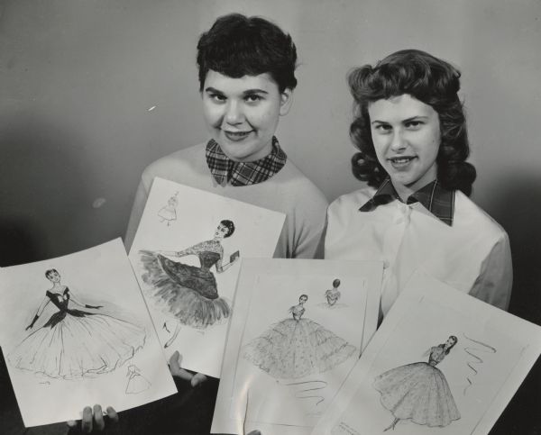 Two young women are holding up four sketches of dresses. Caption reads: "<b>Modest formal dresses</b> were sketched in a contest for pupils of Milwaukee Catholic high schools. Top winners, announced at a convocation Tuesday at St. John's cathedral high school, were Miss Marlene Teska (left), 413 W. Mitchell St., who won the $10 first prize, and Miss Janette Schmitz, 3180 S. 41st St., winner for the $5 second prize. The contest was sponsored by Sodality Union of Milwaukee archdiocese."