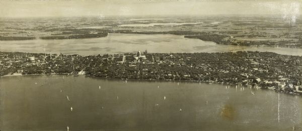 Aerial view looking south over Lake Mendota towards the isthmus and beyond. Sailboats and other boats are on the lake. The view is centered at Wisconsin Avenue and the Wisconsin State Capitol.