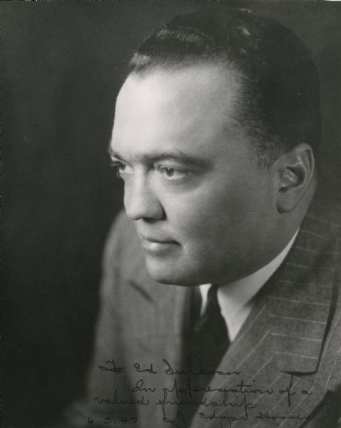 Quarter length left side profile portrait of FBI Director J. Edgar Hoover. Hoover is wearing a pinstriped suit with a white shirt and dark tie. The handwritten inscription reads: "To Ed Sullivan/In appreciation of a/valued friendship/J. Edgar Hoover/6.3.47."