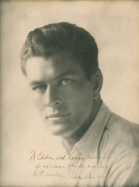 Head and shoulders portrait of boxer Gene Tunney. He is looking directly at the camera and is wearing a white shirt. The handwritten inscription to Ed Sullivan reads: "To Eddie with happy memories/of various camps, and my/best wishes. Gene Tunney."