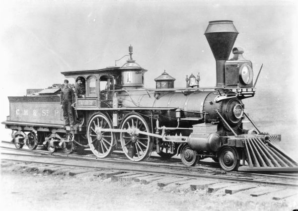 The Chicago, Milwaukee, and St. Paul Railway engine #287, which was built by Mason Locomotive Works in 1860. Two men are standing on the locomotive.