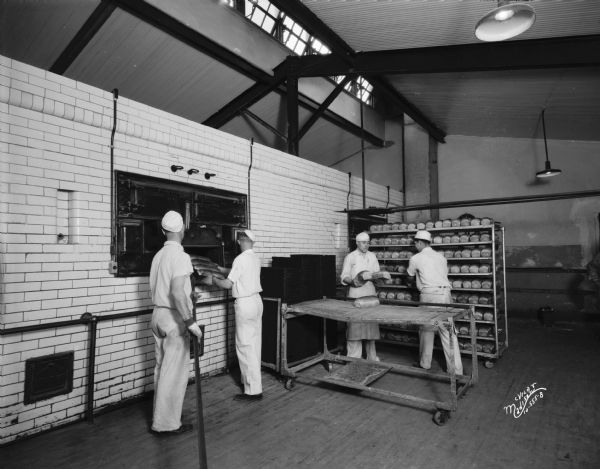Gardner Baking Company, showing men taking Purity Bread from ovens, 849 E. Washington Avenue.