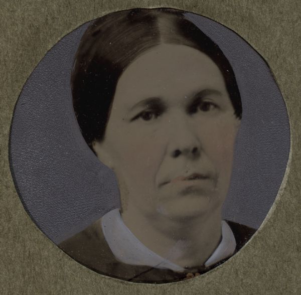 Hand-tinted, round-framed portrait of a woman.