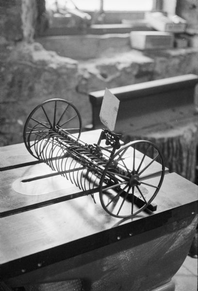 Caption reads: "Intricate detail of scale model is shown in 1900 hay rake. Museum usually draws 12,000 visitors during May to October season, expects big rise this year."