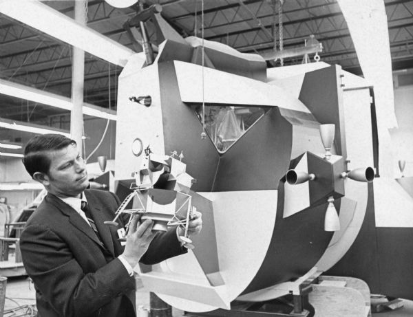 James Kitchell with a small and large model. Caption reads: "MOON SHIP MODEL — James W. Kitchell, executive producer of NB News' color television coverage of the Apollo IX mission which is scheduled for launch from Cape Kennedy, Fla., Friday, Feb. 28, at 11 a.m. NYT, is shown standing in front of NBC News' full-scale mockup of the Apollo IX lunar module holding a model of the moon ship. The 10-day mission will include the first manned test of the two-man moon module. NBC News will use the 24-foot-high mockup of the two-stage space ship located at NBC News Space Center in New York to explain and illustrate what actually is taking place aboard the module during its earth orbital flight. NBC News will present special live color coverage of the Apollo IX mission on the NBC Television Network beginning at 10 a.m. NYT."