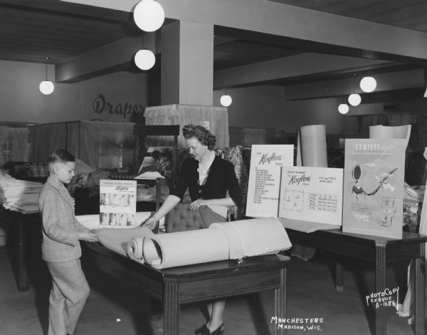 Manchester's, 2-12 East Mifflin Street, drapery department with a female clerk showing Koylon Foam for cushions to a young male customer.