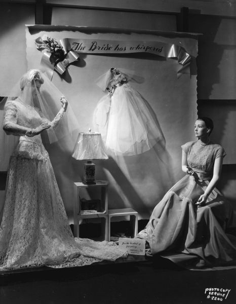 "The Bride Has Whispered" foyer display at Manchester's, Inc., 2 East Mifflin Street, featuring bride and bridesmaid mannequins in wedding attire.