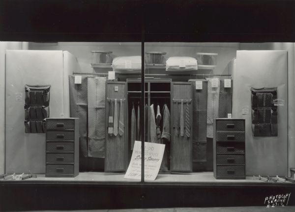 Show window at Hill's Store, 202 State Street, featuring a display of EZ-DO and Princess House Space Savers garment bags, shoe bags, hat boxes and storage chest of drawers for closet storage.