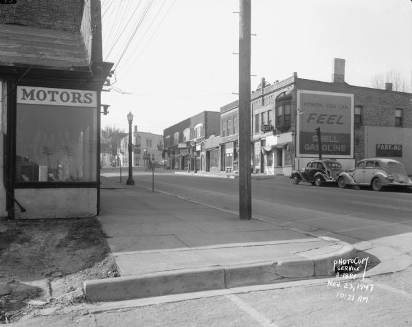 East Wilson Street at corner of South Hancock intersection looking toward West Wilson Street-King Street intersection taken to document site of Reynolds Bus accident scene.  Business seen at near corner is Electric Motor Service at 323 East Wilson Street. Business seen at far corner is Schroeder & Son Funeral Service, 235 King Street.  Businesses seen along north side of East Wilson Street include the Shell Service at 324 East Wilson Street, Young's Cafe at 316 East Wilson Street, Madison Watch Shop at 314 East Wilson Street, Volunteers of America at 310-12 East Wilson Street, Fred Kessenich (United Autographic Register Company) at 308 East Wilson Street, Johnson Maytag Company at 306 East Wilson Street, Meyer Printing at 304 East Wilson Street, and Stop Lite Tavern, 302 East Wilson Street.