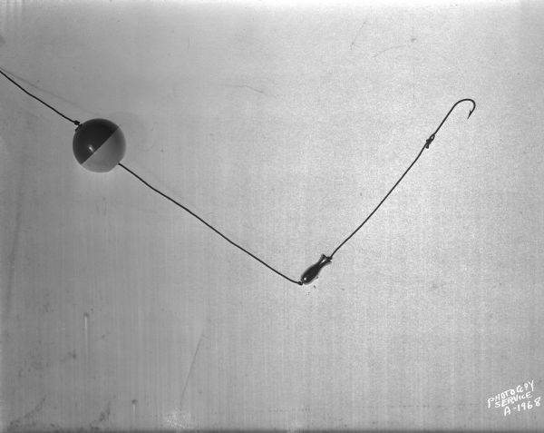 Small nickel-plated fish lure with float and hook, designed by S.R. Blackstone.
