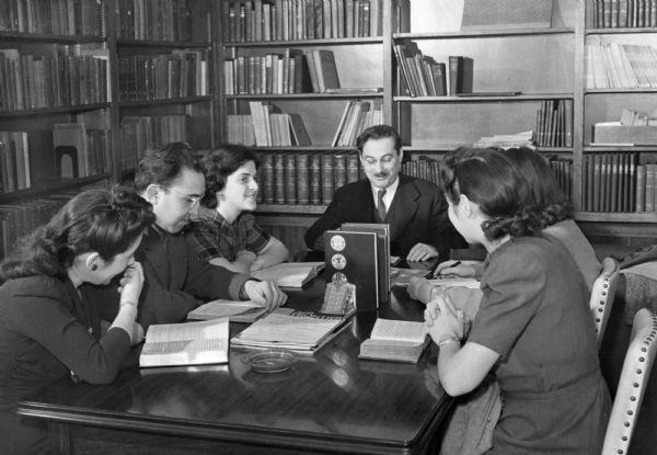 Rabbi Kadushin conducting a class in his study. He is sitting at a table with five students.
