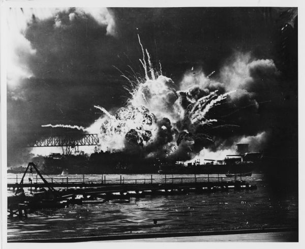 The forward magazines of the USS <i>Shaw</i> exploding after a Japanese bomb set the fore aflame as it sat in dock at Pearl Harbor. The midships and stern of the ship remained intact. The USS was rebuilt to serve in the rest of the war.