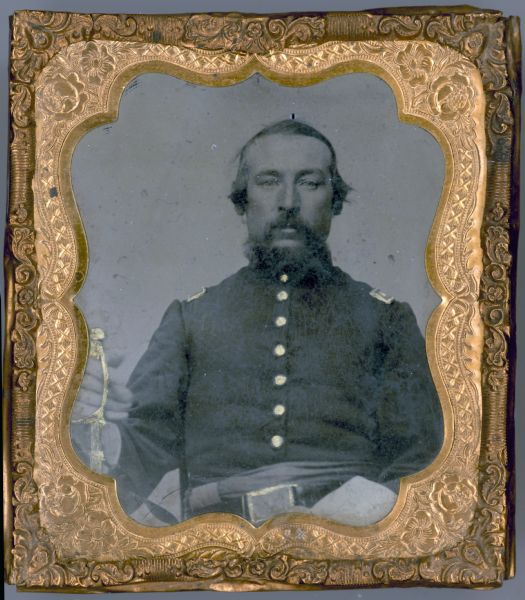 A tintype portrait of Francis Wilson of the Dodgeville Guards, 12th Wisconsin Volunteer Infantry, Company C. The buttons and epaulets on his uniform, as well as his belt buckle and sword, are hand-colored gold.