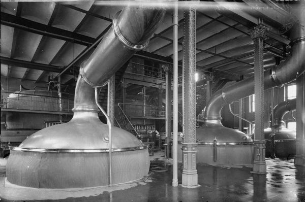 View of the brew house of the Joseph Schlitz Brewing Company. A man is standing in the background.