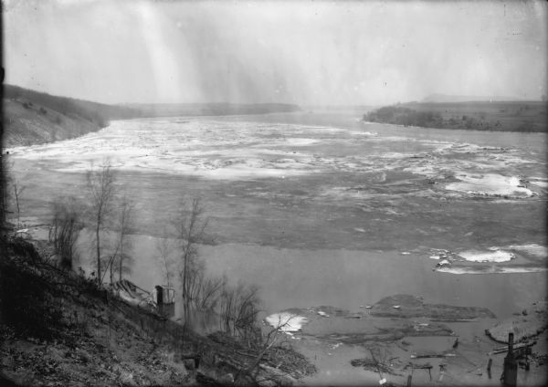View down steep hill at an ice gorge on a river at a power dam.