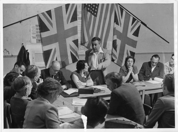 William Belanger (standing) addressing unionists at workers' education school in St. Malo, France. Harold Gibbons and Carmen Lucia are also pictured. 