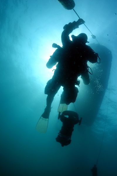 View from below of a diver at an underwater archaeology site ascending to the boat.