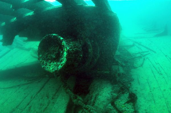 The Pretoria was slowly torn apart by the storm while anchored. Lying upside down on top of the bilge near Pretoria's bow, the heavy anchor windlass remains attached to deck timbers. In the foreground are sections of the anchor chain. 