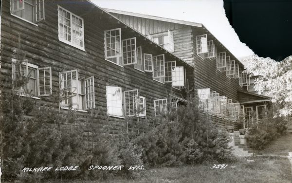 External view along the side of the Kilkare Lodge, which is on a sloping hill. Many of the windows are open.