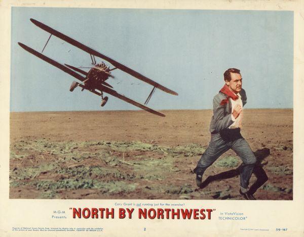 Lobby card for the 1959 film "North by Northwest" starring Cary Grant and Eva Marie Saint.  The card shows Roger Thornhill (Cary Grant) being chased by a crop duster airplane through a field.