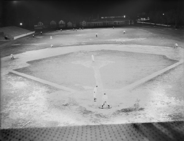 Elevated view of Breese Stevens Athletic Field illuminated at night, with the Madison Blues, Eddie Lenahan, manager, practicing baseball. Alternate view.