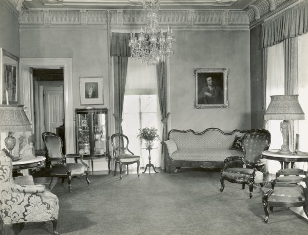 View of the rear of the Parlor. The window on the back wall looks out towards Lake Mendota, and the windows on the right have a view of the side yard. The windows have the original 1850 window sashes. The door on in the left corner leads to the hallway, and further back is a door to the kitchen. 