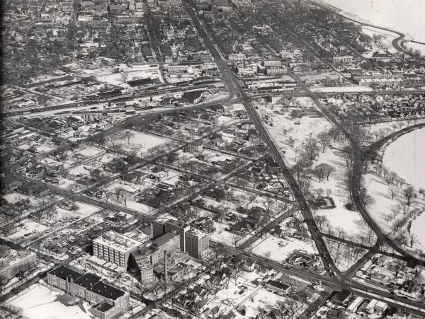 Aerial view of the Greenbush neighborhood in winter partially demolished for the Triangle Redevelopment Project. Monona Bay and Brittingham park are at right. W. Washington Avenue runs top to bottom where it intersects with S. Park Street. Meriter Hospital and Lowell school are at bottom left. The railroad roundhouse is at the intersection of W. Washington Avenue and Regent Street.