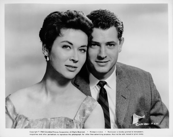 Publicity photograph of actress Gia Scala and her husband actor Don Burnett. Burnett is next to and behind Scala, and the sides of their heads touch.