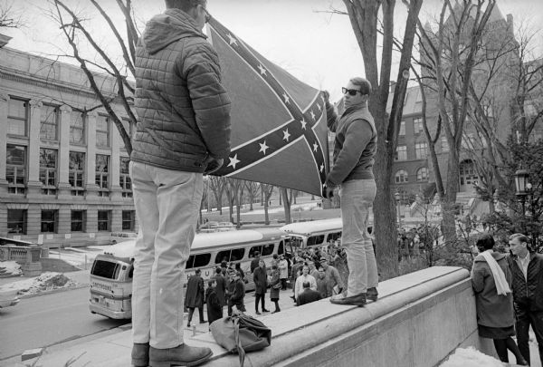 Two Universtiy students wave a Confederate flag on the steps of the University of Wisconsin Memorial Union in protest of the 114 Freedom Riders boarding buses bound for Selma, Alabama in front of the Union.