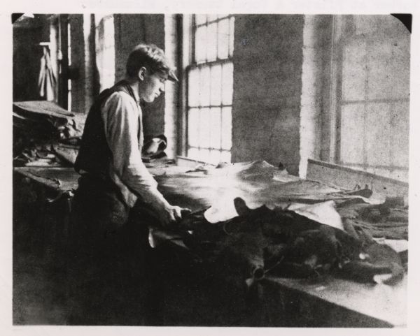 Man working with leather at Pfister and Vogel tannery.