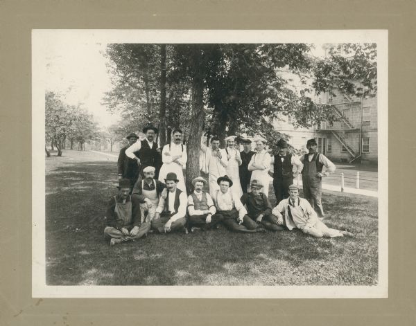 Employees of the Mendota State Hospital posing outdoors in front of a tree.