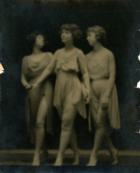 Three dancers pose together with hands clasped. They are Elise du Fore, Frances Wellington, and Gwyneth King Roe.