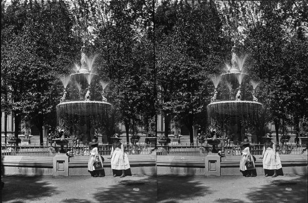 Two young girls standing in front of an ornate fountain in Milwaukee's Courthouse Square. The courthouse and fountain were later demolished, and the square is now known as Cathedral Square Park