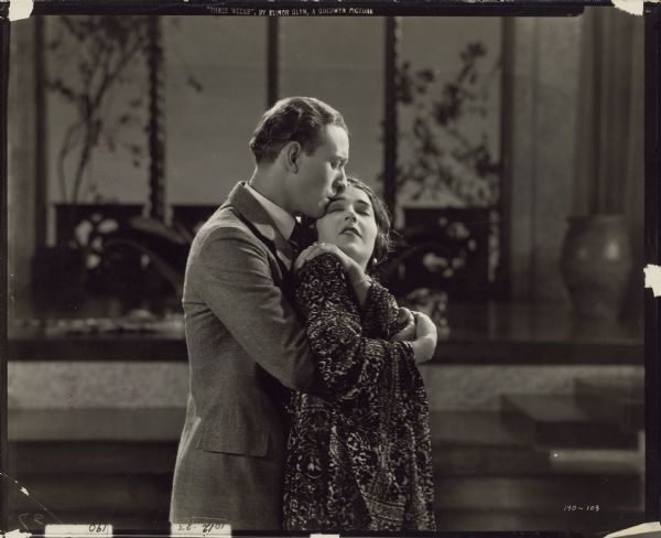 Paul Verdayne (Conrad Nagel) embraces the Queen (Aileen Pringle) from behind in a scene from the 1924 film "Three Weeks". He kisses her forehead as she leans back with her eyes closed.