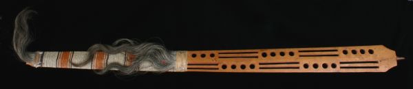 A pipe stem presented to Wisconsin territorial governor James D. Doty at Fort Winnebago. Wooden stem is three inches at widest part. It is flat, half carved, and decorated with quillwork in white, orange, red, and brown with Thunderbird figures on one side. Horse hair and remnants of pileated woodpecker scalp (with some remaining feathers) at either end of quilled section. Lower section pierced with round and elongated rectangular holes with inner surfaces painted red. Handwritten on one side of lower section in ink: "Presented By Tay che gwi au nee for his Father 'The Buffalo' a principal Chippewa chief on south shore of Lake Superior in Council at Fort Winnebaygo [sic] February 12. 1844." 