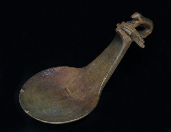 A wooden Ho-Chunk spoon with a figure of an otter carved on the handle.