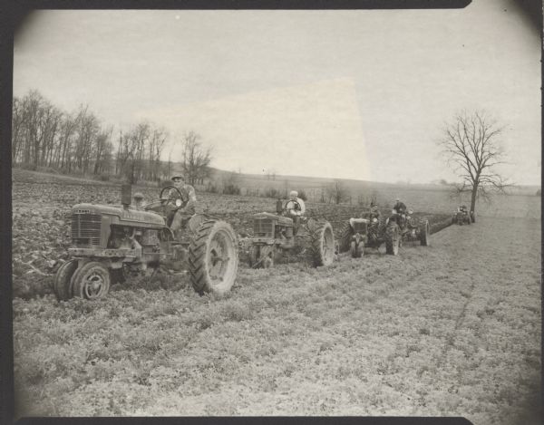 Five men are driving tractors along a field. Caption reads: "Ft Atkinson Wis 1947-9  Weckler farm  Neighbors help Weckler when daughter was kidnapped".