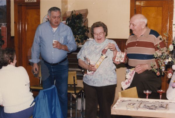 Group of people inside the tavern. Standing are, left to right: Fred Kleba, a friend of the family and customer, Lorraine Wittnebel, and Roy Wittnebel on the last day the tavern was in business. A woman is sitting on the far left. There is a decorated cake in the right foreground, near a tree decorated with eggs.
