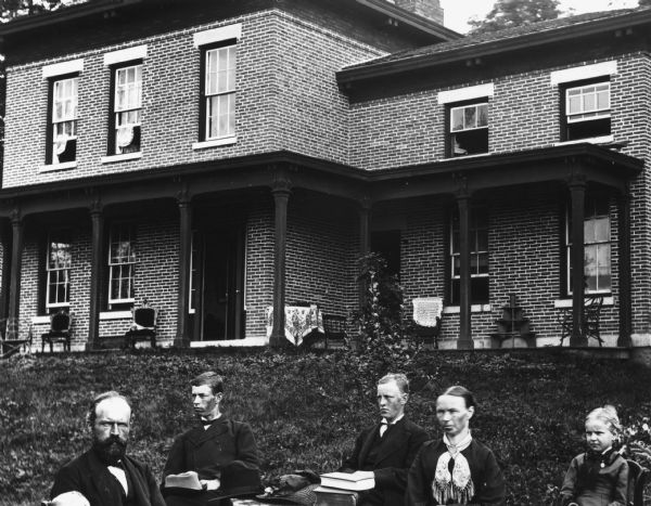 Detail from original of part of the family and the house. Original caption reads: "Halle Steensland and his wife Sophia pose with their five children (left to right: Morten, Henry, Edward, Halbert and Helen) in front of their home in Maple Bluff."