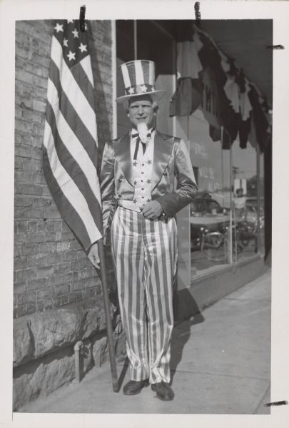 A man posing in an Uncle Sam costume, holding an American flag. Caption reads: "Bill Leppien or Wilburt E. Leppien. 410 N. Livingston St. Commander of Dane County Council Amer. Legion and - member of Donald C. Severson Post 501 The American Legion. "