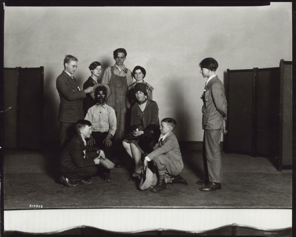 Nine young people posing on stage. One person is in blackface. Caption reads: "Dane County Wis Amateur theatrical group 1923".