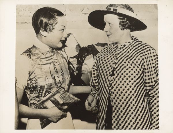 Pearl White welcomed to Shanghai by Virginia Chang, the daughter of the Chinese minster to Chile.  Both women are dressed very nicely.