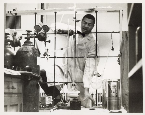 Activist and science teacher George Wiley wearing a white lab coat and a bow tie while teaching a chemistry class.