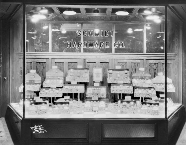 Window display of the Schmidt Hardware Company showing Mirro Aluminum toy sets: dishes and silverware.