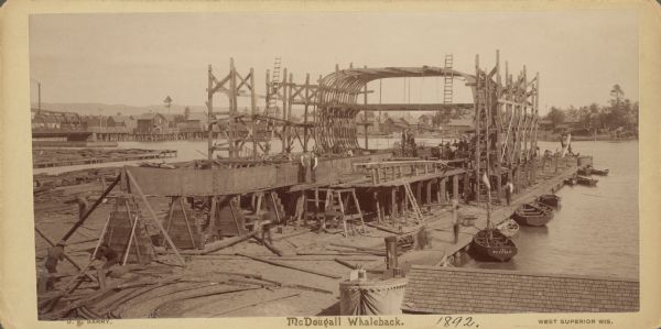Captain Alexander McDougall's whaleback passenger steamer "Christopher Columbus" under construction in the shipyard of the American Steel Barge Company in Superior. Text at bottom right of card reads: "West Superior Wis."