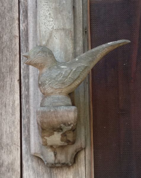 Wooden singing bird carving, mounted on the screen door of Forest Lodge Guest House.
