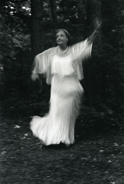 Mary Griggs Burke dressed in a white fringe dress while twirling in a clearing in the woods at Forest Lodge. The photograph was a gift from Mary's cousin Eleanor Briggs who wrote: "Happy Birthday Bertha!", a pet name Eleanore had for Mary.